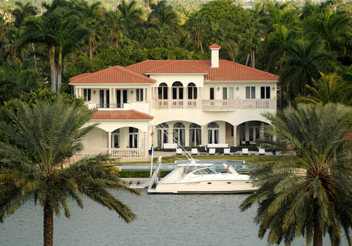 A large white house sitting on top of a lake.