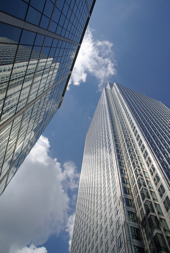 A view of two skyscrapers from below, looking up.
