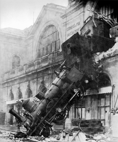A train wreck in front of an old building.
