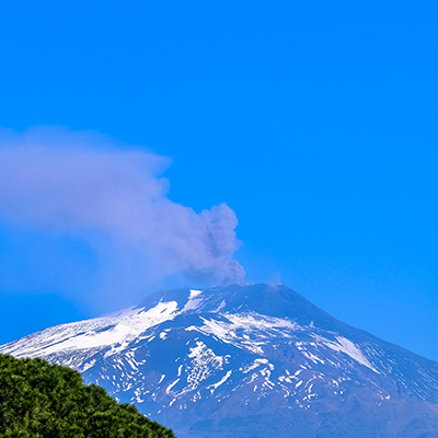 A view of the top of a mountain with smoke coming from it.