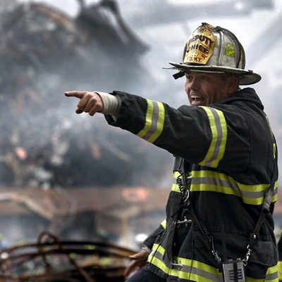 A fireman pointing to something in the distance.